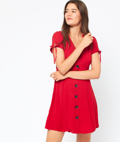 Robe &eacute;vas&eacute;e &agrave; boutons carmin.